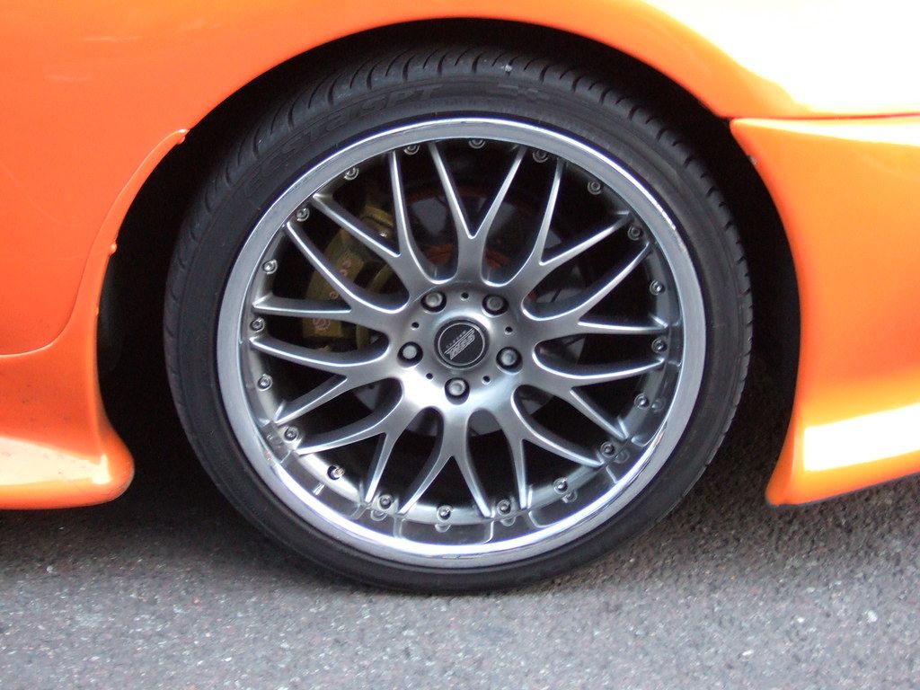 Multi-spoke silver alloy wheel fitted to a low-profile tire on a sports car